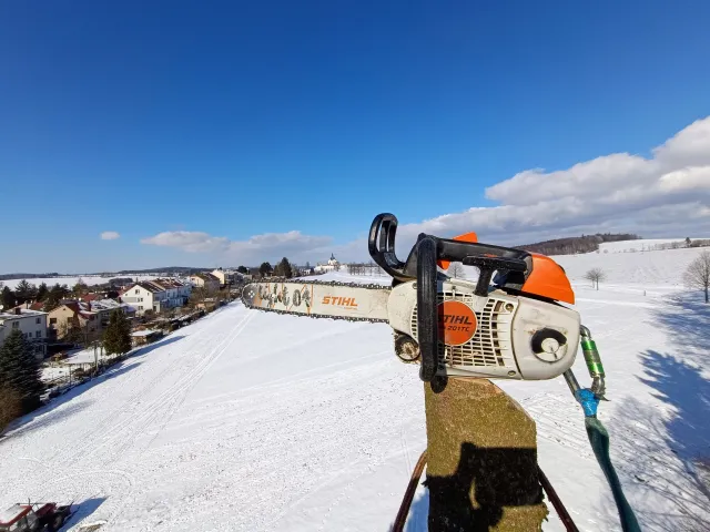 Motorová pila na plošině nad zasněženou krajinou